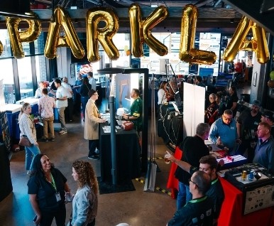 Crowd beneath gold SparkLab balloon letters